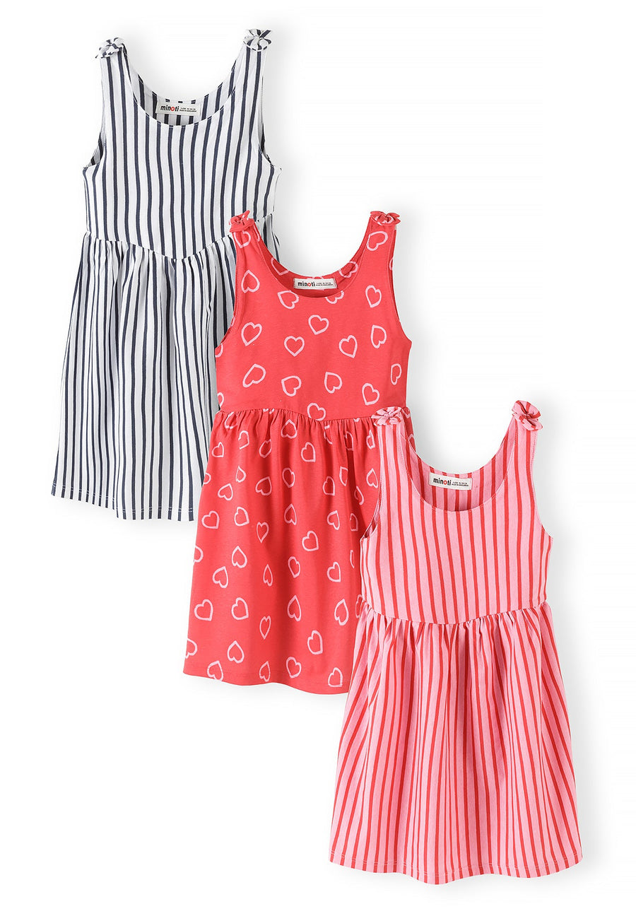 Three sleeveless summer dresses displayed flat - navy striped, coral with white heart print, and pink striped dress with tie shoulder straps
