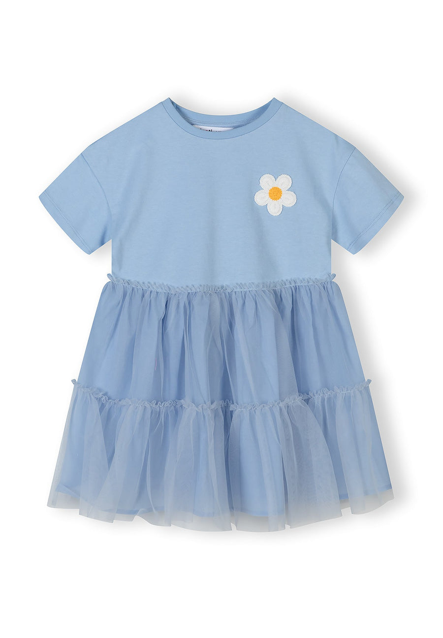 Front view of blue cotton and tulle dress showing layered skirt construction and short sleeves on white background