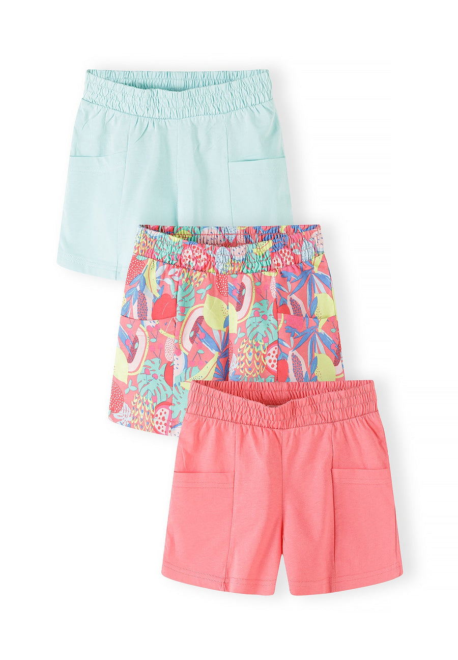Close-up detail of tropical print jersey shorts showing vibrant pineapple, flamingo and palm leaf pattern with elasticated shirred waistband