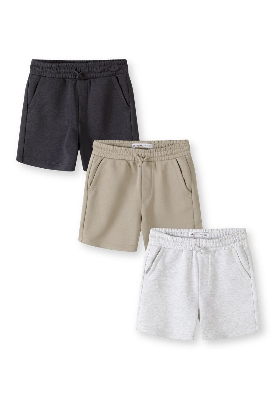 Three pairs of boys shorts stacked showing grey, beige and black colours with elasticated waistbands and side pockets on white background