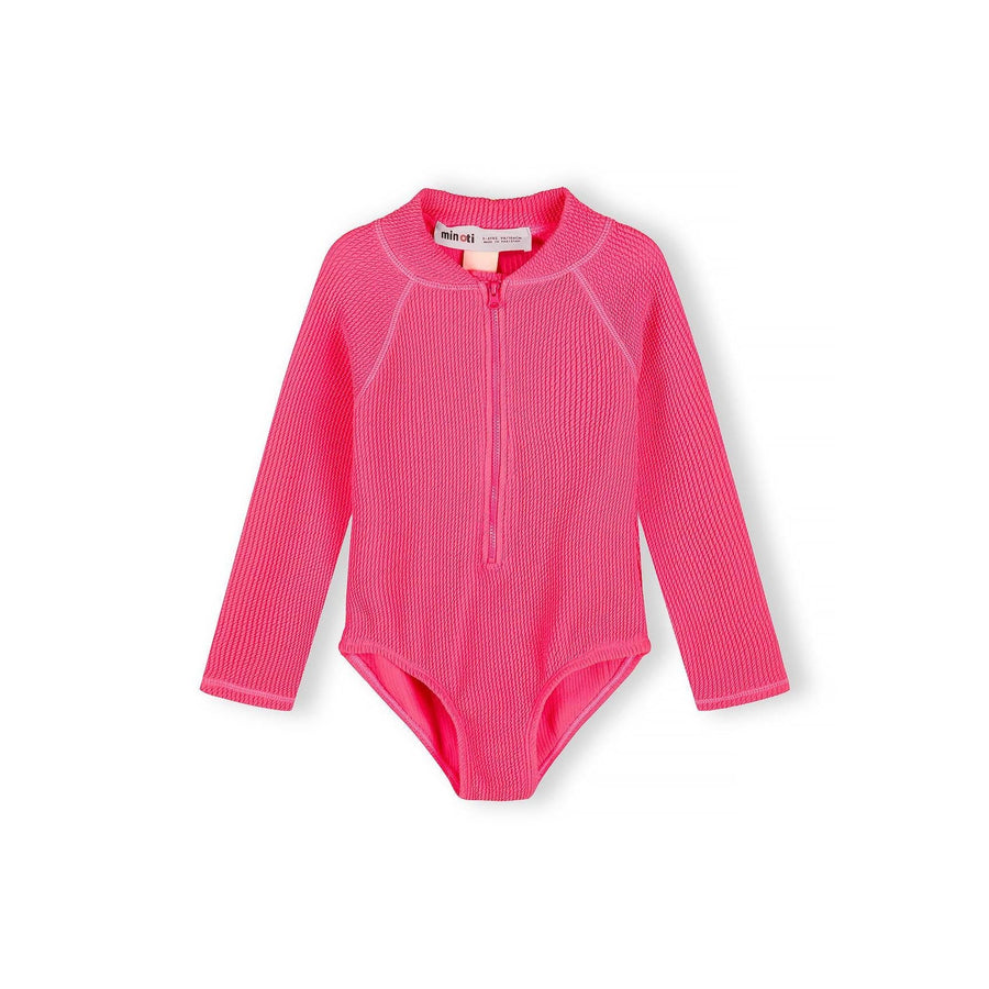 Bright pink long sleeve swimsuit with front zip closure displayed flat on white background, showing ribbed texture and Minoti label